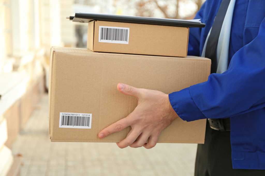 Courier with parcels on doorstep, closeup