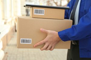 Courier with parcels on doorstep, closeup